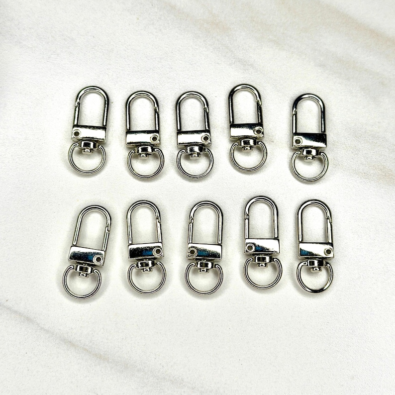Shiny silver and gold 12x33mm swivel lobster clasps for keychains, bag charms, jewelry making, and DIY craft supplies.