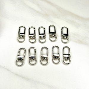 Shiny silver and gold 12x33mm swivel lobster clasps for keychains, bag charms, jewelry making, and DIY craft supplies.