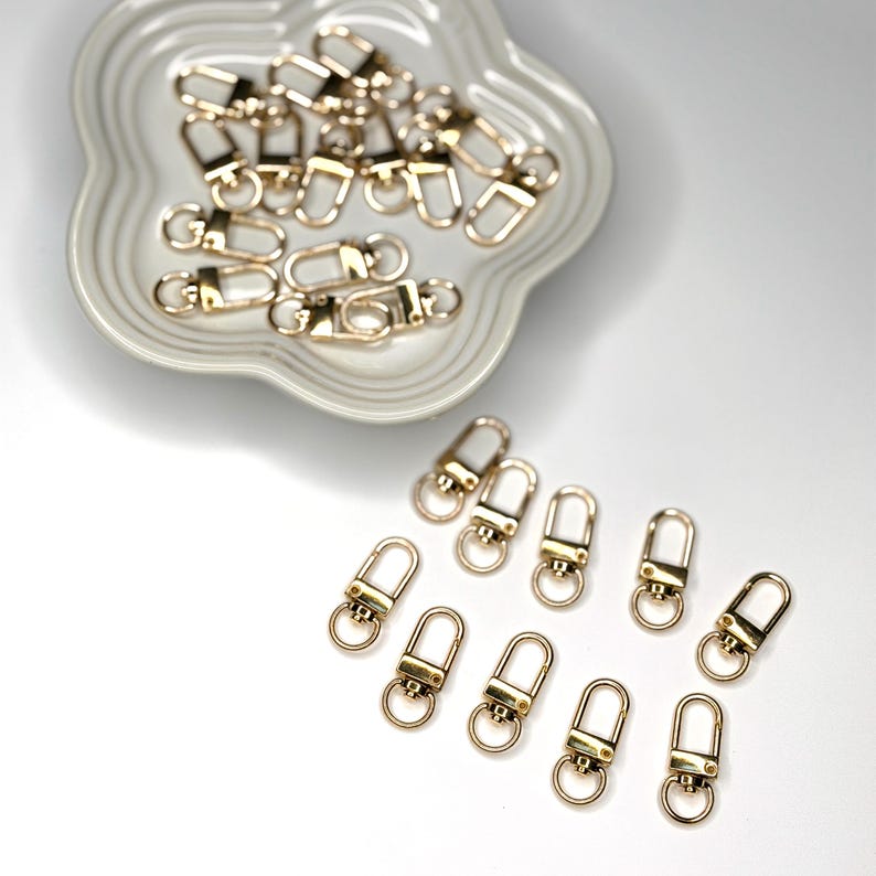 Shiny silver and gold 12x33mm swivel lobster clasps for keychains, bag charms, jewelry making, and DIY craft supplies.