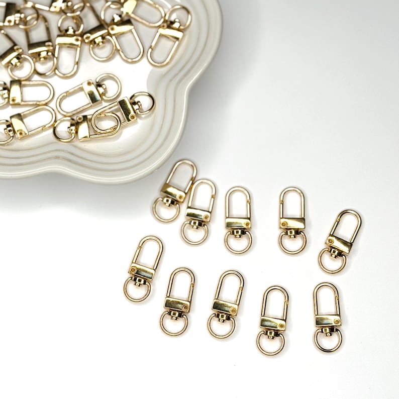 Shiny silver and gold 12x33mm swivel lobster clasps for keychains, bag charms, jewelry making, and DIY craft supplies.