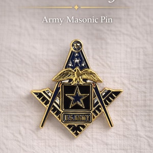 Puede incluir: Pin masónico del ejército con un diseño dorado y azul. El pin presenta un símbolo de escuadra y compás con una estrella y un águila, y el texto "U.S. ARMY". La palabra "Freemasonry" está escrita encima del pin.