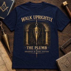 Pode incluir: Uma t-shirt azul-marinho com um gráfico dourado de um prumo pendurado em frente a uma porta em arco com colunas. O texto diz WALK UPRIGHTLY THE PLUMB STEADFAST IN EVERY STATION. O design inclui um símbolo de esquadro e compasso.