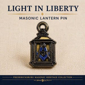May include: A Masonic lantern pin with a black and gold finish. The pin features a blue square and compass symbol within the lantern's frame. The text "LIGHT IN LIBERTY" and "MASONIC LANTERN PIN" are displayed above the pin.