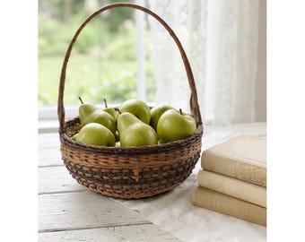 Cesta redonda vintage de vime em dois tons de marrom com alça alta decorativa em formato de laço.