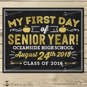 Op de afbeelding: Een zwart schoolbordbord met gouden en witte tekst. Er staat "MY FIRST DAY of SENIOR YEAR!" met de datum 24 augustus 2015 en "CLASS OF 2016". Het bord is wit omlijst.