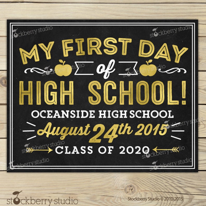 Op de afbeelding: Een zwart schoolbordbord met gouden letters met de tekst "MY FIRST DAY OF HIGH SCHOOL!" met de schoolnaam, datum en klasjaar. Het bord heeft een witte rand en staat op een houten achtergrond.