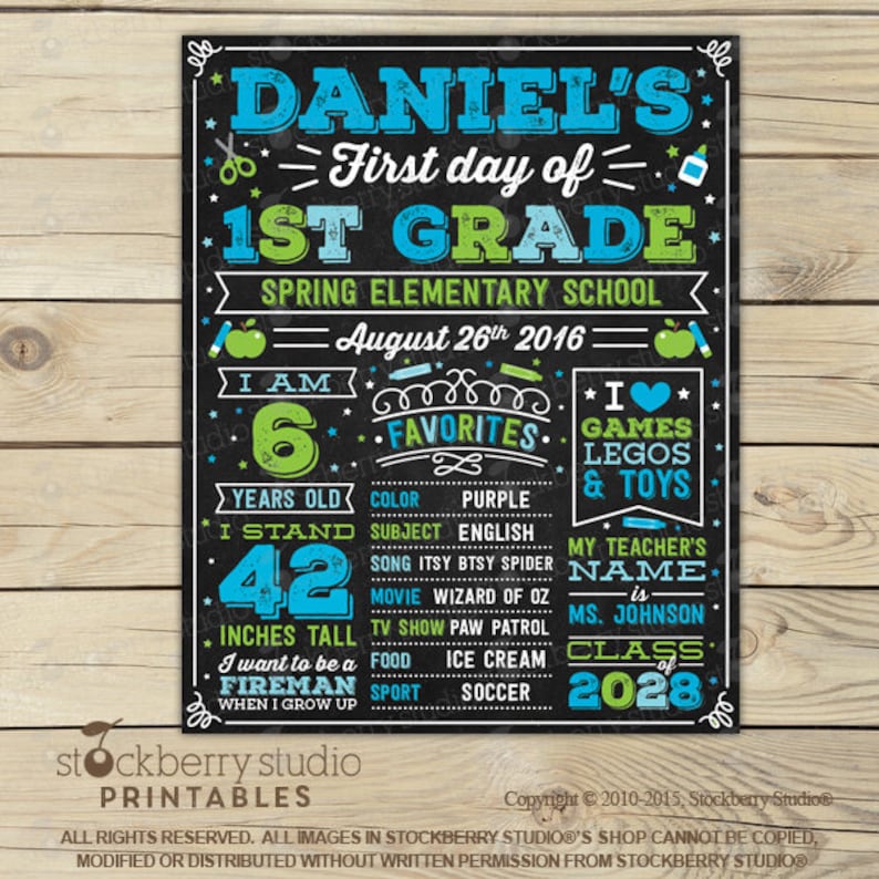 May include: A black chalkboard-style sign with blue and green text and graphics detailing Daniel's first day of 1st grade at Spring Elementary School on August 26th, 2016, including age, height of 42 inches, favorites, and teacher's name.
