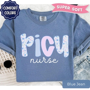 May include: Blue jean colored t-shirt with the words "PICU nurse" in a playful font. The letters "P" and "U" are decorated with a floral pattern, while the "C" has a pink gingham design. The shirt has a "Comfort Colors" label.