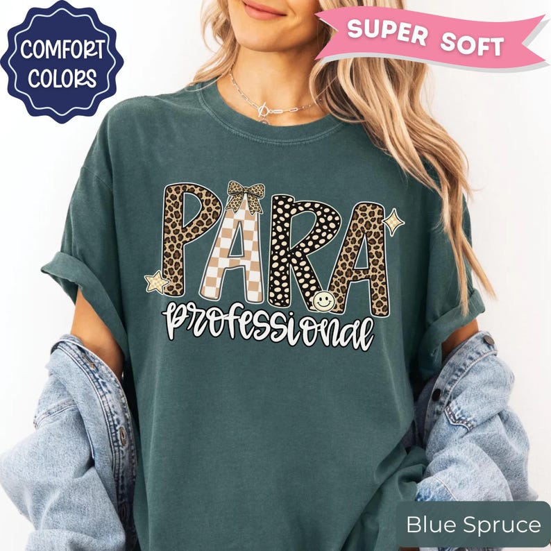 May include: A dark teal t-shirt featuring the text PARA in large letters with leopard print, checkered, and polka dot patterns, and the word professional in white script below. The design includes a small bow, a star, and a smiley face icon.