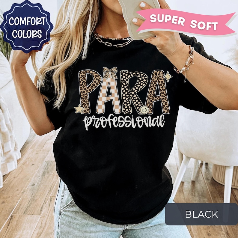 May include: A black t-shirt featuring the text PARA in large letters with a leopard print and checkered pattern, and the word professional in white script below. The design includes small star and smiley face icons and a bow graphic.