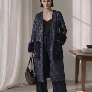 May include: A longline coat featuring a dark blue fabric with a gold geometric pattern, open front, and deep navy faux fur cuffs on the sleeves and large patch pockets. The text reads: Delphine Coat Sewing Pattern PDF, Longline Coat Pattern XS-4XL.