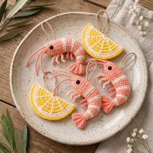 May include: Two crocheted prawn ornaments in shades of pink and white with black bead eyes, and two crocheted lemon slice ornaments in bright yellow and white. Each ornament features a small jute twine loop for hanging.