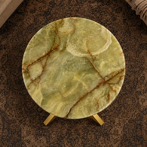 Handmade round onyx table top with organic brown veins and smooth polished surface
Natural green onyx furniture centerpiece styled with contemporary gold metal stand