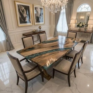 May include: A wooden dining table with a teal resin river design, surrounded by six upholstered chairs. The room is decorated with a chandelier, artwork, and curtains. The table is a focal point in an elegant dining room setting.