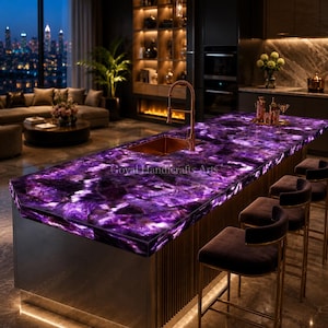 May include: A kitchen island featuring a striking purple countertop with a marbled design. A copper tap and sink are installed. The island is complemented by dark brown bar stools with gold accents. The kitchen is in a modern, well-lit space. The countertop is approximately 300 cm long.