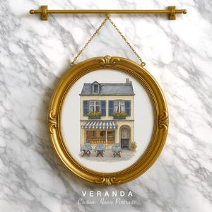 May include: An oval gold-framed print of a French bakery, suspended from a gold rod. The image depicts a building with a blue and white striped awning, blue shutters, and small tables and chairs. The text "VERANDA Custom House Portraits" is at the bottom.