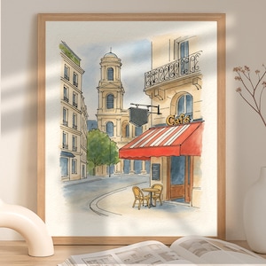 May include: Watercolor painting of a Parisian street scene. The artwork features a cafe with a red and white striped awning, a church, and buildings with architectural details. The painting is framed in a light brown wooden frame.