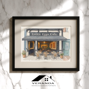 Puede incluir: Pintura a la acuarela de un café con el texto "Green Eggs Cafe" sobre la entrada. El café tiene asientos al aire libre con mesas y sillas. La obra de arte está enmarcada en un marco negro y es un retrato de casa en acuarela.