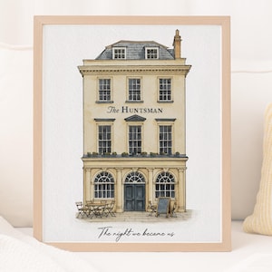 May include: A framed watercolour illustration of a three-storey building labelled The Huntsman, featuring a dark blue door, arched windows, and outdoor seating. Below the building, the text reads The night we became us in black script.