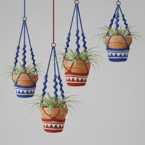 May include: Four hanging terracotta planters with green plants. Each pot is suspended by a blue macrame hanger. The pots are decorated with white and red crochet patterns. The background is a solid light gray.