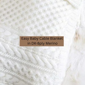 May include: A close-up of a white baby cable knit blanket. The blanket features a textured design with cable knit and diamond patterns. The text "Easy Baby Cable Blanket in DK-8ply Merino" is visible.