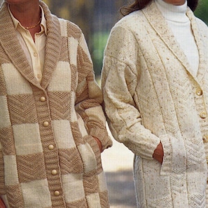 May include: Two long, button-down knit cardigans. One is a checkerboard pattern in cream and tan. The other is a solid cream color with a textured knit. Both have pockets and shawl collars. The cardigans are part of a knitwear collection.