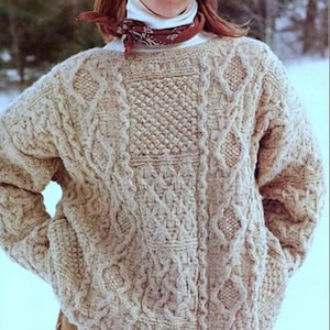 May include: A beige cable-knit sweater with intricate patterns. The sweater features a textured design with diamond and cable patterns. The long-sleeved garment is made of a thick, warm material, perfect for cold weather. The sweater is a classic, cozy style.