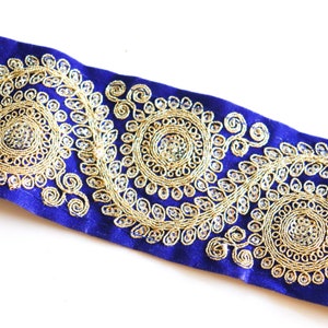 May include: Blue velvet trim with gold embroidery featuring a repeating pattern of circular designs.
