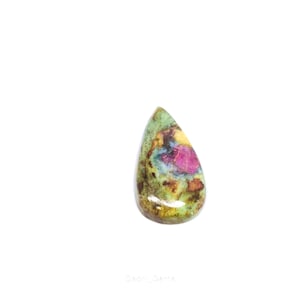May include: A teardrop-shaped gemstone with a mix of colors. The stone features a vibrant pink center surrounded by green, yellow, and brown hues. The polished surface reflects light, showcasing the stone's natural patterns.