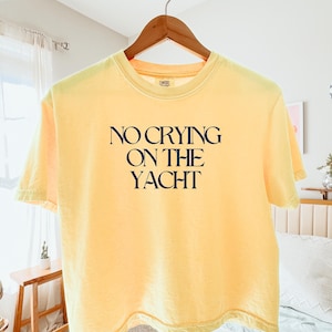 May include: A white ceramic mug with a black handle and the text "But First, Coffee" in a black, bold font. The mug is on a white surface.