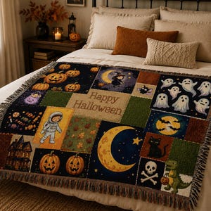May include: A woven throw blanket featuring a patchwork design with Halloween motifs including pumpkins, ghosts, a black cat, a skull, a dinosaur, an astronaut, a haunted house, and a crescent moon, with the text Happy Halloween in the centre.
