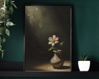 May include: An oil painting of a white daisy with a yellow center and pink accents in a small, beige vase. The artwork is set against a dark, textured background with a spotlight effect, creating a dramatic contrast. The painting is framed in a black frame.