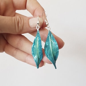 Può includere: Orecchini a forma di foglia di colore blu turchese con ganci argentati.