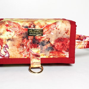 May include: A red and yellow fabric pouch with a phoenix design and a gold ring handle. The pouch has a red border and the text "Custom Made" on a gold tag.