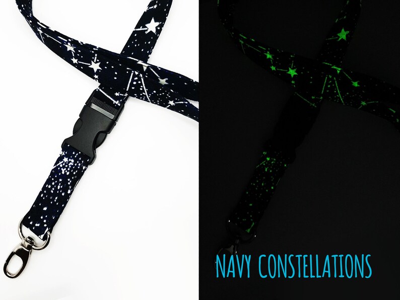 May include: A navy blue lanyard with white constellations that glow green in the dark. The lanyard has a black plastic clip and a silver swivel hook.  NAVY CONSTELLATIONS is printed on the lanyard.