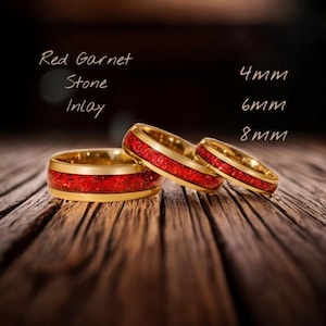 May include: Three gold rings with red garnet stone inlays, displayed on a wooden surface. The rings are labeled with sizes 4mm, 6mm, and 8mm. The text "Red Garnet Stone Inlay" is also present.