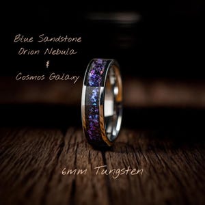 Könnte beinhalten: Silberfarbener Wolframring mit einem 6 mm breiten Band. Der Ring hat einen Einsatz aus blauem Sandstein, lila Orionnebel und Cosmos Galaxy. Der Text lautet "Blue Sandstone Orion Nebula Cosmos Galaxy".