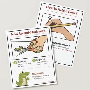 Pode incluir: Dois cartões instrutivos com ilustrações e texto sobre como segurar um lápis e uma tesoura. O cartão "Como Segurar a Tesoura" apresenta um jacaré de desenho animado e instruções. O cartão "Como Segurar um Lápis" mostra uma mão segurando um lápis. Ambos os cartões têm bordas pretas.
