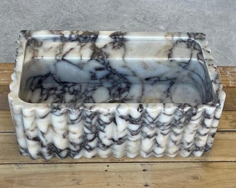 May include: A rectangular marble sink with a scalloped edge, featuring a white and black veined pattern. The sink is set on a rustic wooden pallet-style stand, showcasing a natural wood grain.
