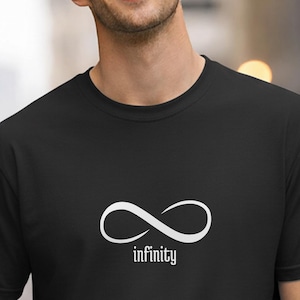 Può includere: Una t-shirt nera a maniche corte con girocollo caratterizzata da un simbolo dell'infinito bianco centrato sul petto. Sotto il simbolo dell'infinito, la parola infinity è stampata in un carattere bianco minuscolo in stile serif.