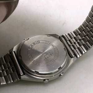 May include: A close-up of the back of a silver Casio watch with a stainless steel band. The watch face is silver with the words "CASIO STAINLESS STEEL JAPAN B 600595" engraved on it.