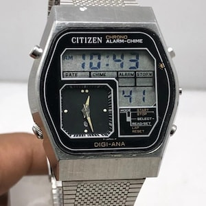 Może przedstawiać: Zegarek Citizen Digi-Ana w stylu vintage ze srebrnym metalowym paskiem i kopertą. Czarna tarcza zegarka wyświetla czas cyfrowo i analogowo. Zegarek posiada przyciski funkcyjne i widoczny jest napis "CITIZEN CHRONO ALARM-CHIME". Pasek ma około 20 cm.