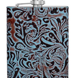 May include: A rectangular metal flask featuring a light blue and dark brown embossed floral pattern across its surface. The container is topped with a silver-coloured screw-top cap attached to a hinged metal arm for secure closure and easy access.