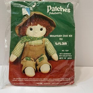 Puede incluir: Un kit de muñeca de montaña de Titan, con una muñeca con sombrero marrón, pelo rojo y peto. La muñeca mide 35,5 cm de alto. El kit incluye tela, hilo e instrucciones.