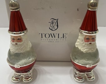 May include: Two Santa Claus salt and pepper shakers with red hats, white beards, and silver boots. The shakers feature clear glass midsections filled with white material. They are positioned in front of a white box labeled Towle Silversmiths Since 1690.