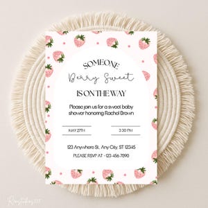 May include: A baby shower invitation with a strawberry theme. The invitation features the text "SOMEONE Berry Sweet IS ON THE WAY" and details for the event, including the date, time, and location. The design includes pink strawberries.