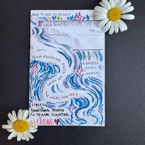 May include: A hand-drawn art piece with blue and white swirls, red stars, and text including "THE TIME IS RIGHT" and "YOUR PERFUME." Lyrics from "Something Stupid" by Frank Sinatra are also present. Two daisies frame the artwork.