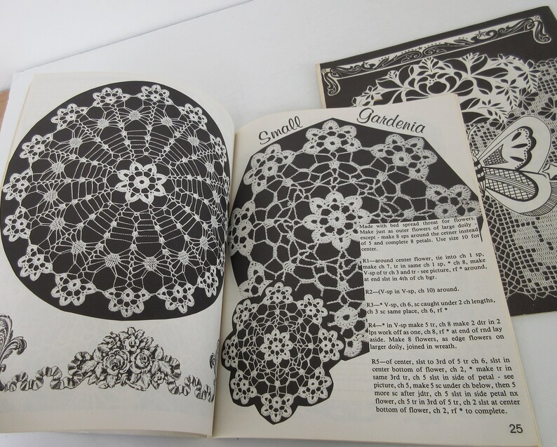 K&ouml;nnte beinhalten: Ein H&auml;kelmusterbuch mit Anleitungen zum H&auml;keln eines kleinen und eines gro&szlig;en Gardenien-Doilys. Das Buch enth&auml;lt eine Schwarzwei&szlig;illustration der fertigen Doilys und eine Nahaufnahme der H&auml;kelstiche.