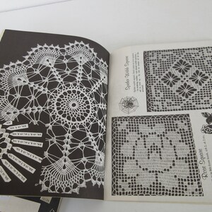 K&ouml;nnte beinhalten: Ein Vintage-H&auml;kelbuch mit Anleitungen zum H&auml;keln eines Spinnennetz-Quadrats, eines Rosenquadrats und einer Doily. Das Buch hat schwarze Seiten und wei&szlig;e H&auml;kelmuster.