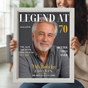 May include: A framed poster featuring a magazine cover titled LEGEND AT 70. The cover displays a portrait of a gray-haired person in a gray shirt with text including THE MAN, THE MYTH, THE LEGEND, EST. 1956, BETTER THAN EVER, and 70TH BIRTHDAY EDITION.